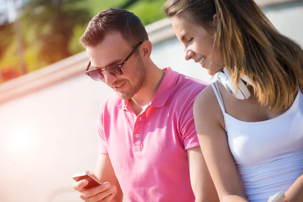 Lachende paar gebruikend smartphone — Stockfoto