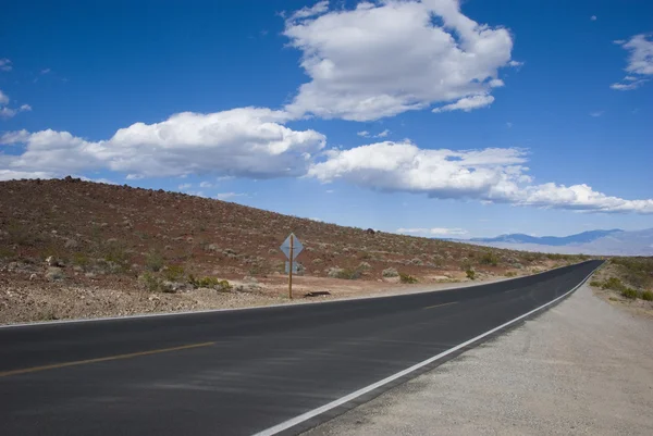 Lunga strada diritta nel paesaggio arido del deserto californiano — Foto Stock