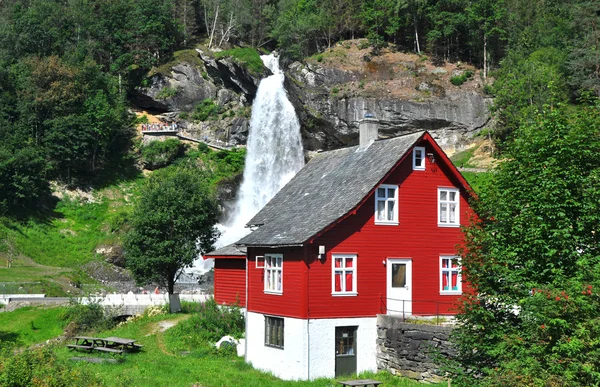 Skandinaviska röda trähus och vattenfall i Norge — Stockfoto