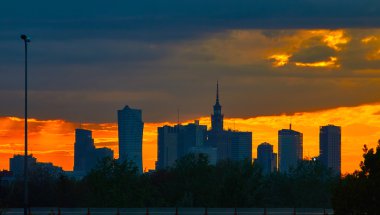 Warsaw, Poland - May 04, 2016: Sunset in the City center of , with silhouettes Palace Culture and Science - PKiN - skyscrapers. clipart