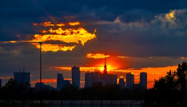 Warsaw, Poland - May 04, 2016: Sunset in the City center of , with silhouettes Palace Culture and Science - PKiN - skyscrapers. clipart