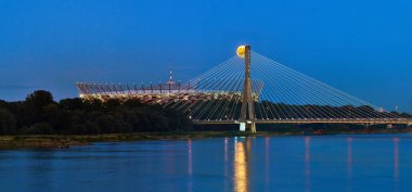 Varşova, Polonya - 20 Temmuz 2016: Polonya Başkenti Ulusal Stadyumu ve Swietokrzyski Köprüsü üzerinde yükselen dolunay panoramik görünümü.