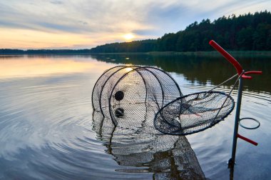 Beautiful view of the sunset with net for fish over Lemiet lake in Mazury district, Poland. Fantastic travel destination. clipart
