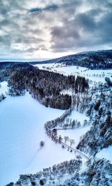 Bir kar yağışı sırasında Stolowe dağlarındaki kış manzarasında güzel panoramik hava aracı manzarası. Stolowe Dağları Ulusal Parkı, Polonya, Avrupa.
