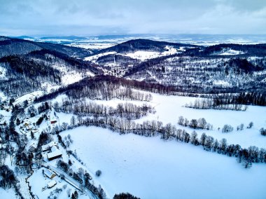 Bir kar yağışı sırasında Stolowe dağlarındaki kış manzarasında güzel panoramik hava aracı manzarası. Stolowe Dağları Ulusal Parkı, Polonya, Avrupa.