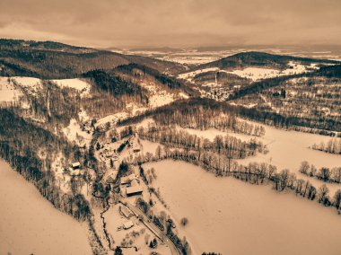 Bir kar yağışı sırasında Stolowe dağlarındaki kış manzarasında güzel panoramik hava aracı manzarası. Stolowe Dağları Ulusal Parkı, Polonya, Avrupa.