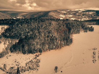 Bir kar yağışı sırasında Stolowe dağlarındaki kış manzarasında güzel panoramik hava aracı manzarası. Stolowe Dağları Ulusal Parkı, Polonya, Avrupa.