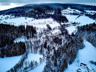 Bir kar yağışı sırasında Stolowe dağlarındaki kış manzarasında güzel panoramik hava aracı manzarası. Stolowe Dağları Ulusal Parkı, Polonya, Avrupa.