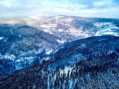 Bir kar yağışı sırasında Stolowe dağlarındaki kış manzarasında güzel panoramik hava aracı manzarası. Stolowe Dağları Ulusal Parkı, Polonya, Avrupa.