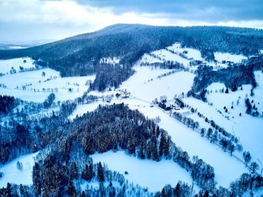 Bir kar yağışı sırasında Stolowe dağlarındaki kış manzarasında güzel panoramik hava aracı manzarası. Stolowe Dağları Ulusal Parkı, Polonya, Avrupa.