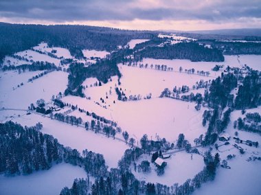 Bir kar yağışı sırasında Stolowe dağlarındaki kış manzarasında güzel panoramik hava aracı manzarası. Stolowe Dağları Ulusal Parkı, Polonya, Avrupa.