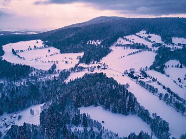 Bir kar yağışı sırasında Stolowe dağlarındaki kış manzarasında güzel panoramik hava aracı manzarası. Stolowe Dağları Ulusal Parkı, Polonya, Avrupa.