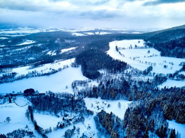 Bir kar yağışı sırasında Stolowe dağlarındaki kış manzarasında güzel panoramik hava aracı manzarası. Stolowe Dağları Ulusal Parkı, Polonya, Avrupa.