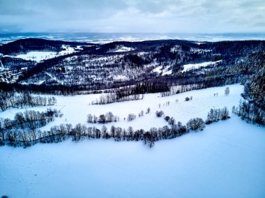 Bir kar yağışı sırasında Stolowe dağlarındaki kış manzarasında güzel panoramik hava aracı manzarası. Stolowe Dağları Ulusal Parkı, Polonya, Avrupa.