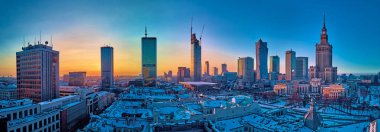 WARSAW, POLAND - JANUARY 31, 2021: Beautiful panoramic aerial drone view on Warsaw City Skyscrapers, PKiN, and Varso Tower under construction and 19th-century tenement houses during the January sunset clipart