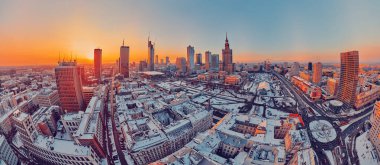 WARSAW, POLAND - JANUARY 31, 2021: Beautiful panoramic aerial drone view on Warsaw City Skyscrapers, PKiN, and Varso Tower under construction and 19th-century tenement houses during the January sunset clipart