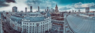 WARSAW, POLAND - February 05, 2021: Beautiful panoramic aerial drone view on Warsaw City Skyscrapers, PKiN, and Varso Tower under construction and 19th-century tenement houses during the february sunset clipart