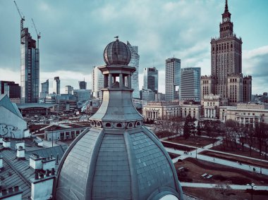 WARSAW, POLAND - February 05, 2021: Beautiful panoramic aerial drone view on Warsaw City Skyscrapers, PKiN, and Varso Tower under construction and 19th-century tenement houses during the february sunset clipart