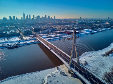 Gökdelenler ve Swietokrzyski Köprüsü (En: Holy Cross Bridge) ile Varşova şehir merkezine yapılan güzel panoramik kış hava aracı görüntüsü Polonya 'nın Varşova kentindeki Vistula nehri üzerinde kablo destekli bir köprüdür.
