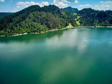 Czorsztyn Gölü 'nün güzel panoramik manzarası (Lehçe: Jezioro Czorsztynskie), Polonya' nın güneyindeki Dunajec nehri üzerinde Pieniny ve Gorce Dağları arasında bulunan insan yapımı bir rezervuardır.