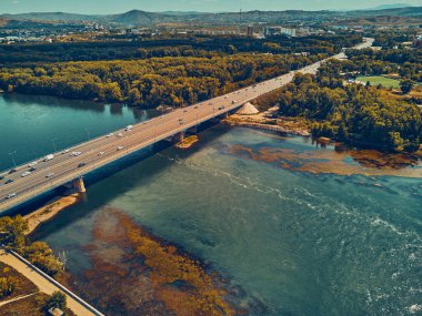 Irak-KAMENOGORSK (Oskemen), QAZAQSTAN 'daki Irtysh Nehri üzerindeki köprünün güzel panoramik hava aracı gün batımı görüntüsü