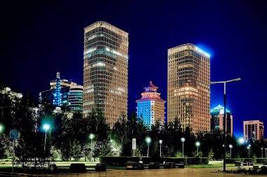 Beautiful panoramic aerial night illumination drone top-down view to Astana (Nur-Sultan) city center with skyscrapers and Baiterek Tower - symbol of Kazakh people freedom, and Khan Shatyr Entertainment Center (ASTANA, NUR-SULTAN, KAZAKHSTAN, QAZAQSTA