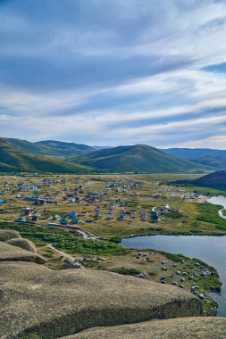 Doğu Kazakistan 'daki Sibinskiye Gölleri' nin çarpıcı yüksek açılı panoramik manzarası. Görüntü, eşsiz, engebeli granit dağ sırtları ve bulutlu gökyüzünün altındaki kaya oluşumları arasında yuva yapmış birkaç derin mavi göl sergiliyor.