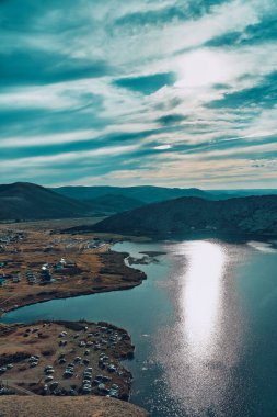Doğu Kazakistan 'daki Sibinskiye Gölleri' nin çarpıcı yüksek açılı panoramik manzarası. Görüntü, eşsiz, engebeli granit dağ sırtları ve bulutlu gökyüzünün altındaki kaya oluşumları arasında yuva yapmış birkaç derin mavi göl sergiliyor.