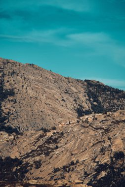 Doğu Kazakistan 'daki Sibinskiye Gölleri' nin çarpıcı yüksek açılı panoramik manzarası. Görüntü, eşsiz, engebeli granit dağ sırtları ve bulutlu gökyüzünün altındaki kaya oluşumları arasında yuva yapmış birkaç derin mavi göl sergiliyor.