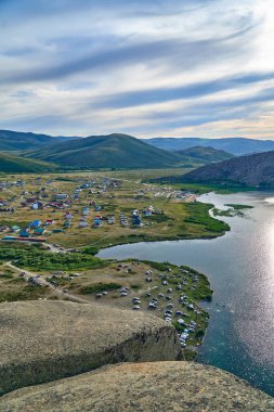 Doğu Kazakistan 'daki Sibinskiye Gölleri' nin çarpıcı yüksek açılı panoramik manzarası. Görüntü, eşsiz, engebeli granit dağ sırtları ve bulutlu gökyüzünün altındaki kaya oluşumları arasında yuva yapmış birkaç derin mavi göl sergiliyor.