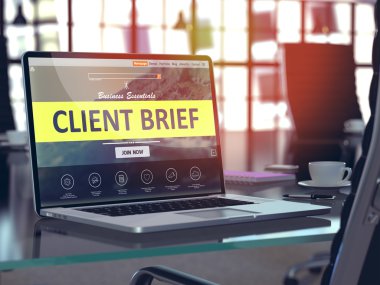 Client Brief on Laptop in Modern Workplace Background.
