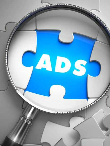 Ads - Missing Puzzle Piece through Magnifier. — Stock Photo, Image