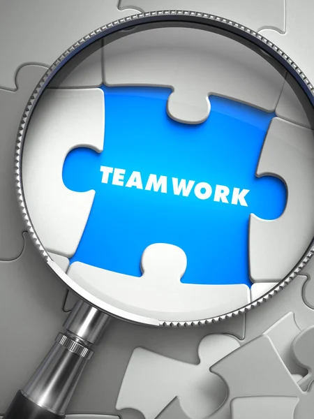 Teamwork - Missing Puzzle Piece through Magnifier. — Stock Photo, Image