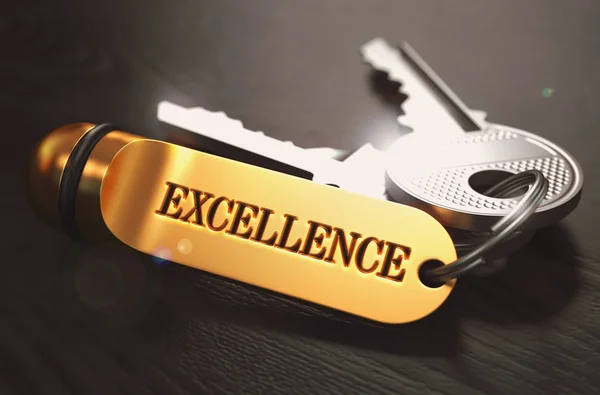 Sleutels naar uitmuntendheid. concept op gouden sleutelhanger. — Stockfoto