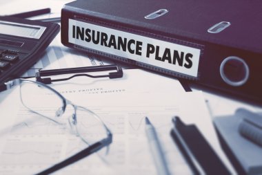 Insurance Plans on Ring Binder. Blured, Toned Image. clipart