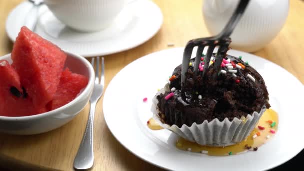 Att Bita Chokladmuffins Toppning Med Honung Och Regnbåge Strössel Vit — Stockvideo