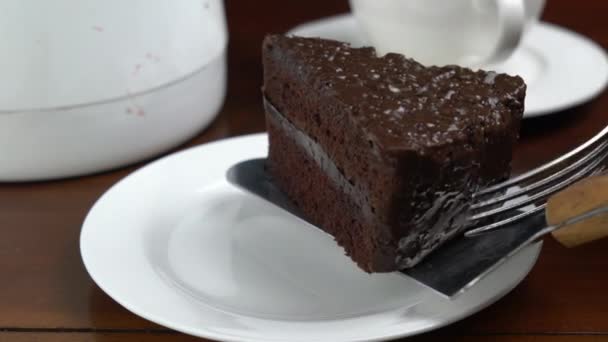초콜릿 케이크 조각을 세라믹 접시에 놓는다 금속제 케이크 사용하여 케이크 — 비디오