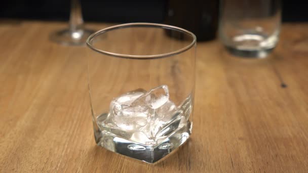 Nalít Whisky Sklenice Naplněné Kostkami Ledu Dřevěném Stole — Stock video