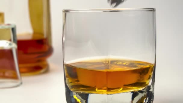 Použití Kleští Led Kapka Kostky Ledu Skla Naplněné Whisky Bílém — Stock video