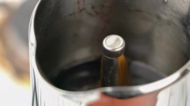 Moka demlik kahve makinesindeki delikten akan kaynamış kahvenin yakın görüntüsü..