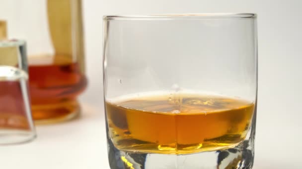 Scena Zbliżeniem Wkładania Kostek Lodu Szklanki Wypełnionej Whisky Białym Tle — Wideo stockowe