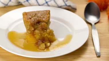 Taze meyveli kekten bir ısırık alıyorum, beyaz seramik tabakta bal döküyorum, ahşap masada. Metal kaşık kullanan yaşlı adam beyaz seramik bir tabaktan taze mango meyveli kek ısırıyor..