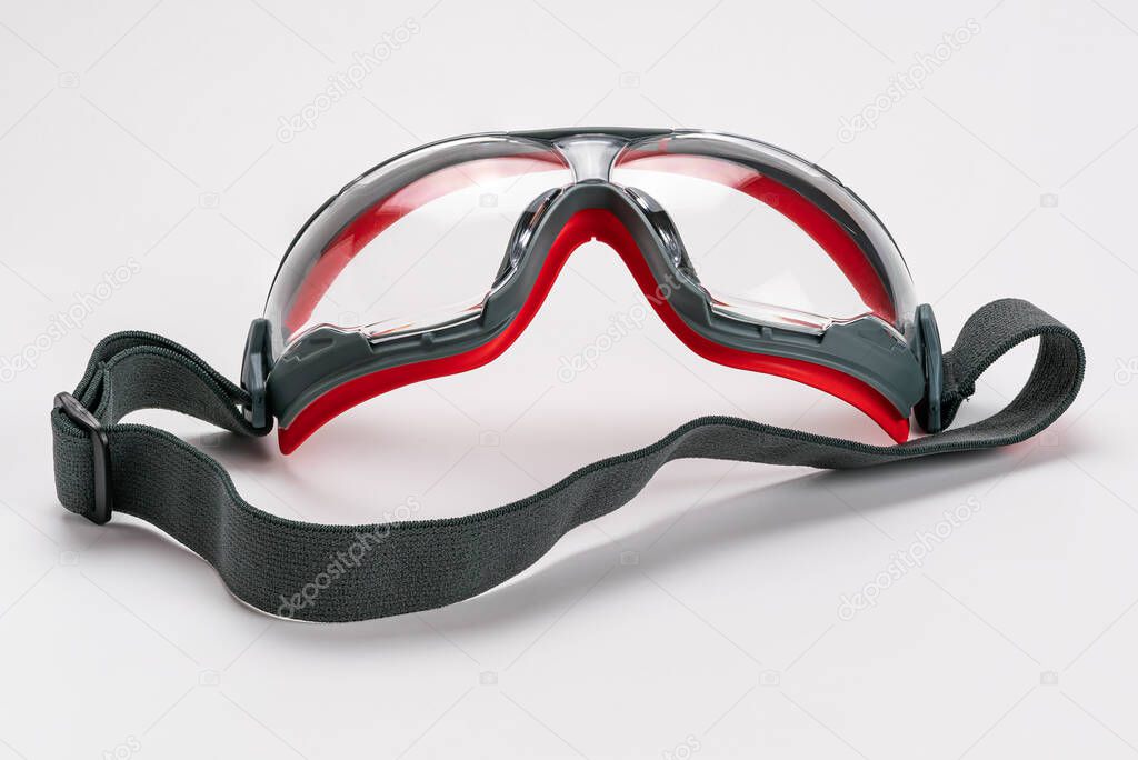 Red frame working goggles with black elastic strap on white background with clipping path.