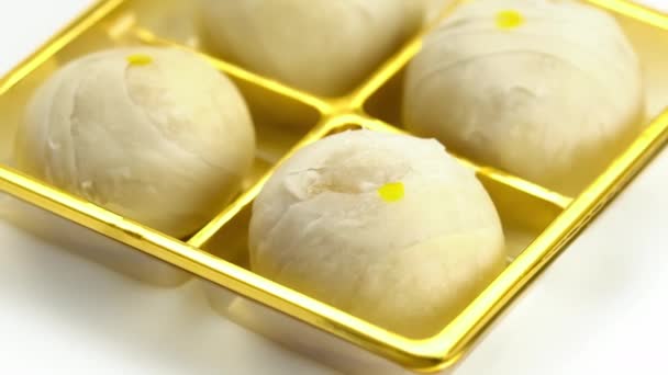 白を基調とした金色の箱の中に 餡入りの甘い豆と塩卵の黄身が入った中国菓子や豆のケーキの高い角度の眺め — ストック動画