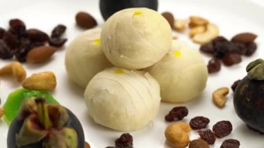 Çin hamur işi veya bezelyeli kek. İçi tatlı mung fasülyesi ve tuzlu yumurta sarısı, badem, kaju fıstığı, kuru üzüm, kivi ve beyaz arka planda mangosteen ile dolu..