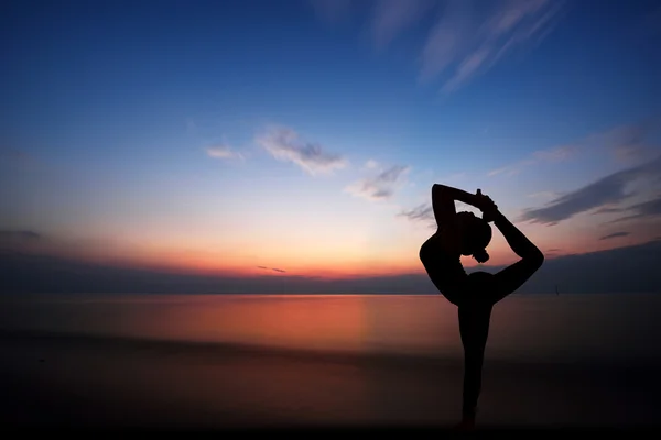 Vrouw doet yoga bij zonsondergang — Stockfoto