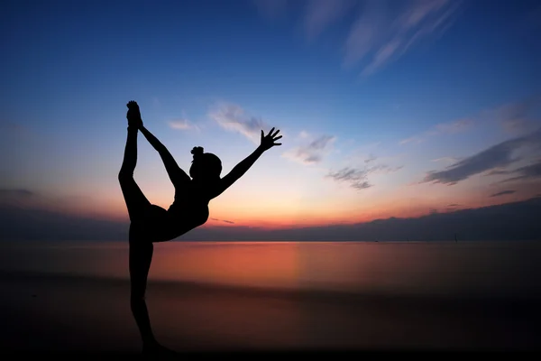 Mulher fazendo ioga ao pôr do sol — Fotografia de Stock