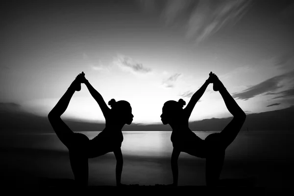 Women doing yoga at sunset — Stock Photo, Image