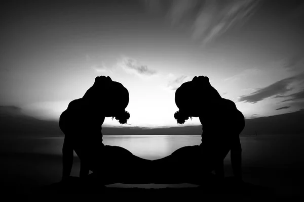 Women doing yoga at sunset — Stock Photo, Image