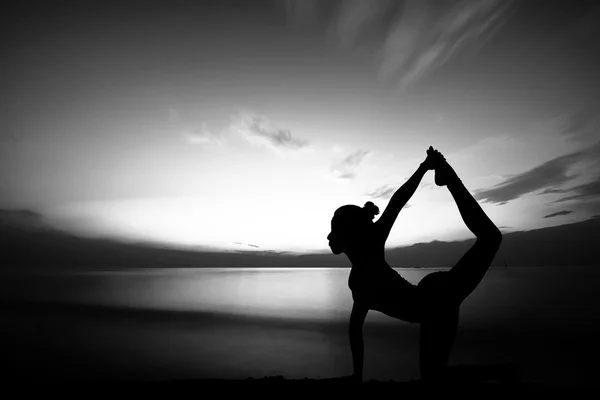 Femme faisant du yoga au coucher du soleil — Photo
